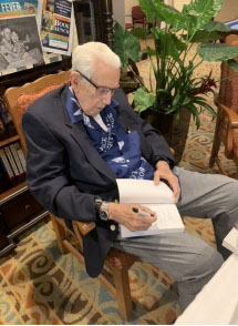 senior resident Charlie autographing books